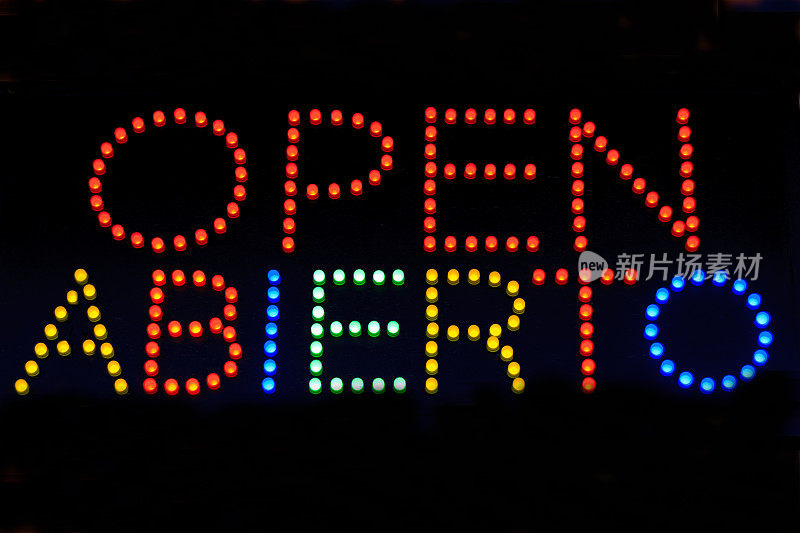 黑色窗户上的“OPEN/ABIERTO”霓虹灯标识